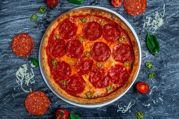 Foto diavolo picante de pizza em fundo escuro de madeira