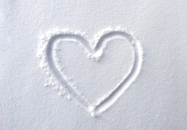 dibujado a mano en forma de corazón en la nieve fresca