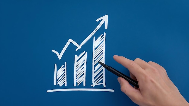 Dibujando a mano un gráfico creciente sobre un fondo azul que significa éxito