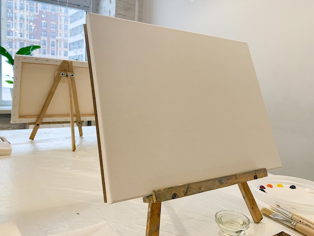 Dibujar pintura al óleo sobre lienzo lienzo blanco en el caballete configurar un lugar de trabajo de artistas de clase de pintura