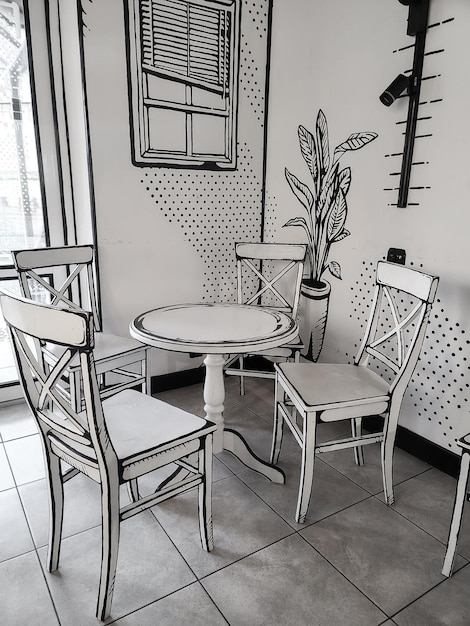 Un dibujo en blanco y negro de una mesa y sillas en una habitación con un reloj en el diseño interior de la pared