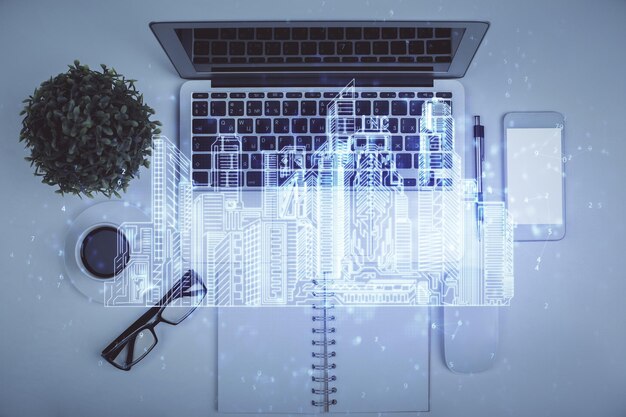 Dibujo de la ciudad sobre la computadora en el fondo del escritorio Vista superior Doble exposición Concepto de hogar inteligente