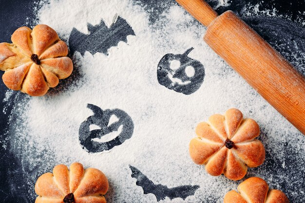 Dibujo de decoraciones de Halloween sobre fondo de harina, pasteles en forma de calabaza