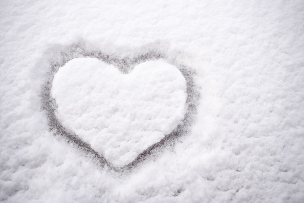 Dibujo en forma de corazón sobre la nieve blanca