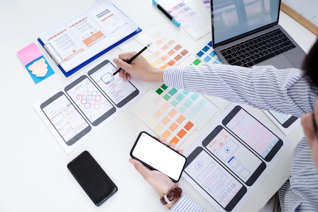Dibujo manual de pantallas para el desarrollo de sitios web responsivos móviles con UIUX Desarrollo de maquetes de diseño de bocetos de wireframe en la pantalla de un teléfono inteligente
