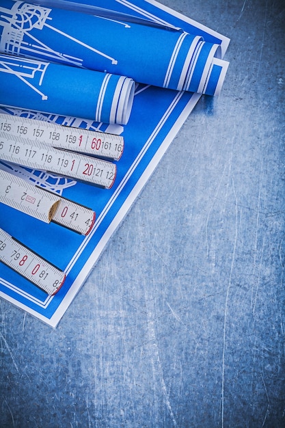 Foto dibujos de construcción azul medidor de madera sobre fondo metálico concepto de mantenimiento