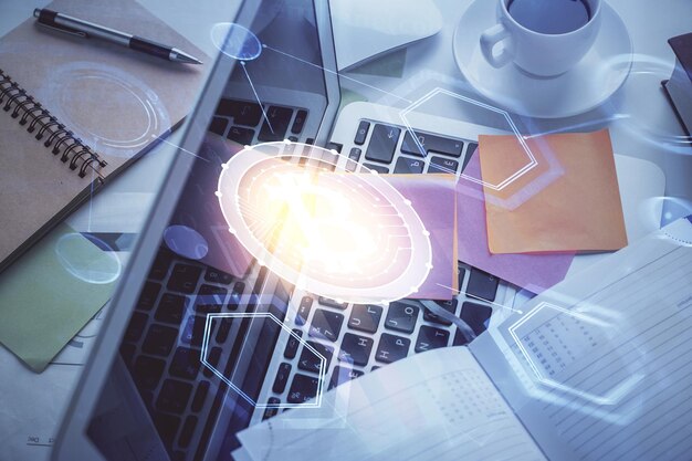 Dibujos de hologramas del tema Blockchain sobre la computadora en el fondo del escritorio Vista superior Concepto de exposición múltiple de criptoeconomía