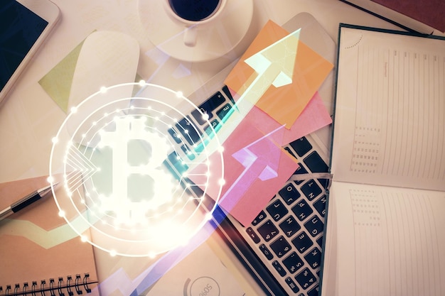 Dibujos de hologramas del tema Blockchain sobre la computadora en el fondo del escritorio Vista superior Concepto de exposición múltiple de criptoeconomía
