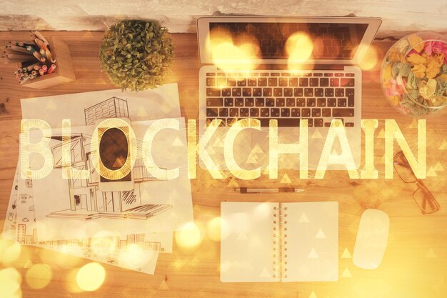 Dibujos de hologramas del tema Blockchain sobre la computadora en el fondo del escritorio Vista superior Doble exposición