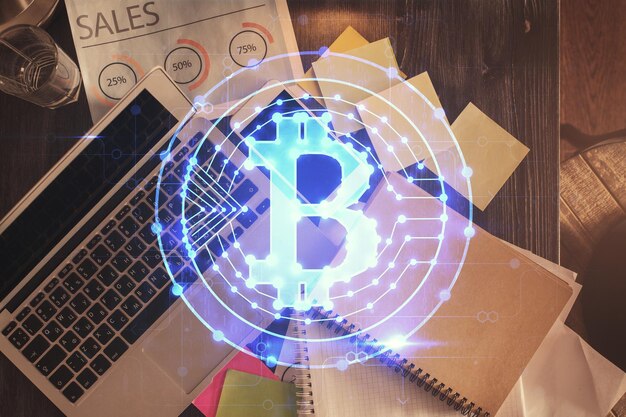 Dibujos de hologramas del tema Blockchain sobre la computadora en el fondo del escritorio Vista superior Doble exposición