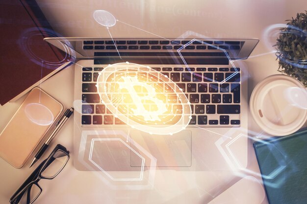 Dibujos de hologramas del tema Blockchain sobre la computadora en el fondo del escritorio Vista superior Doble exposición