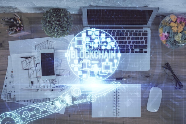 Dibujos de hologramas del tema Blockchain sobre la computadora en el fondo del escritorio Vista superior Doble exposición