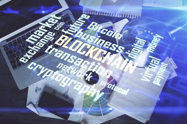Dibujos de hologramas del tema Blockchain sobre la computadora en el fondo del escritorio Vista superior Doble exposición