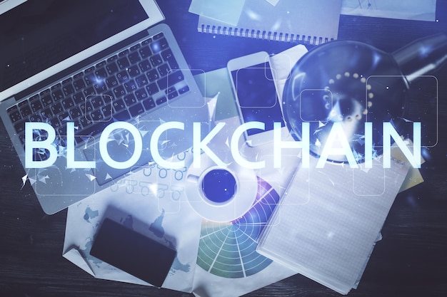 Dibujos de hologramas del tema Blockchain sobre la computadora en el fondo del escritorio Vista superior Doble exposición