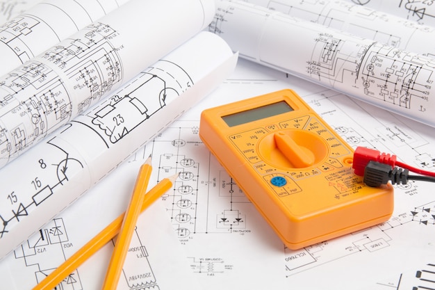 Dibujos de ingeniería eléctrica, lápiz y multímetro digital.