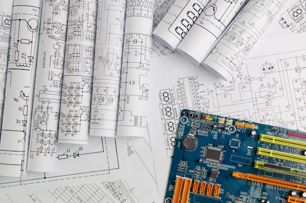 Dibujos de ingeniería eléctrica en papel y placa base de computadora