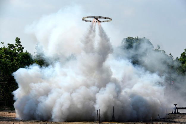 Dichter weißer Rauchstrahlstrom aus kreisförmiger Flügelrakete in einer buddhistischen Zeremonie, Thailand