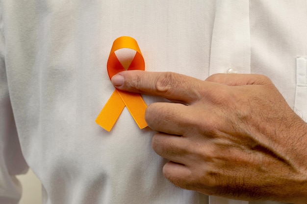 Diciembre de Orange, Campaña Nacional de Prevención del Cáncer de Piel. Mano que sostiene la cinta naranja.