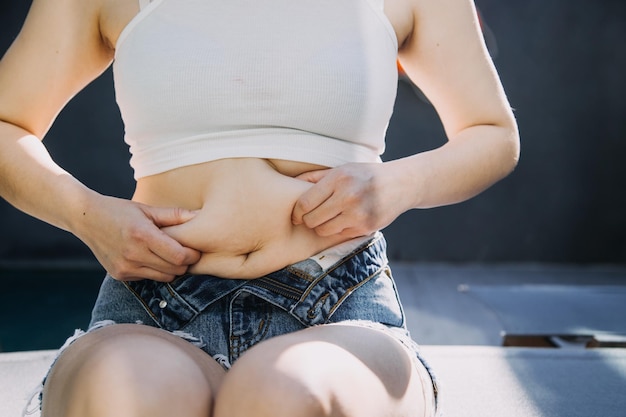 Foto dicke frau dicker bauch mollige fettleibige frau hand hält übermäßiges bauchfett mit maßband frau diät lifestyle-konzept