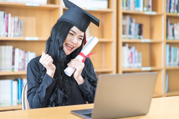 Die Absolventin einer asiatischen Universität feiert mit der Familie per Videoanruf in einer virtuellen Einberufung