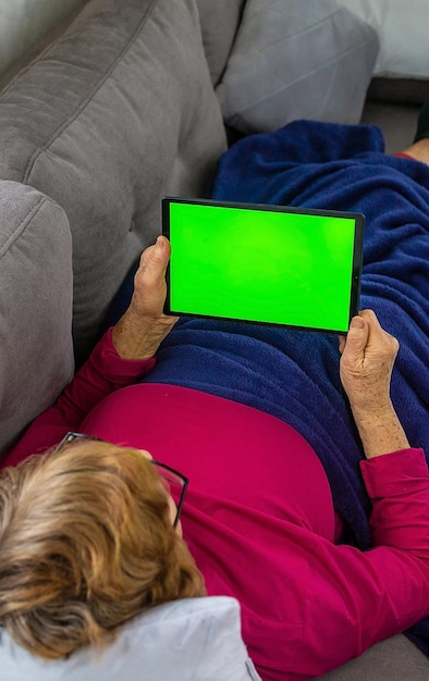 Die alte Frau klickt auf das Tablet Selektiver Fokus