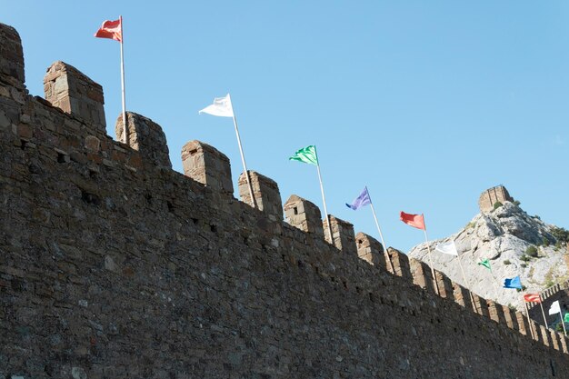 Die alte Mauer der Festung mit bunten Flaggengebäuden aus altem Stein