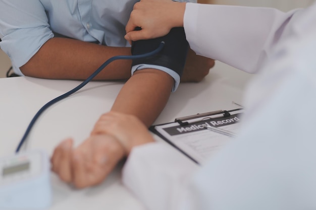 Die Arztin benutzt das Pulsmesser, um den Druck des Patienten zu messen.