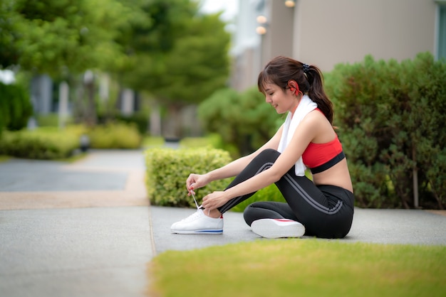 Die asiatische Schönheit, die für sitzt, entspannen sich und versuchende Spitzee im Guss ihres Hauses im Dorf, glücklich und lächeln am Morgen während des Sonnenlichts. Asiatische Ethnie des Sporteignungsmodells, die Konzept im Freien ausbildet.