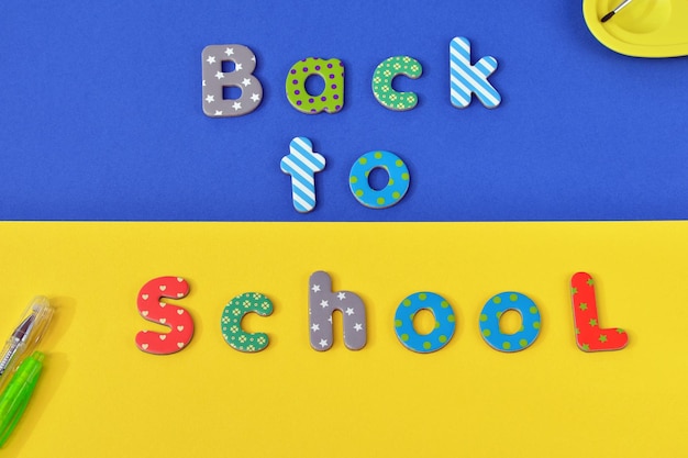 die Aufschrift „Zurück zur Schule“ auf gelbblauem Hintergrund