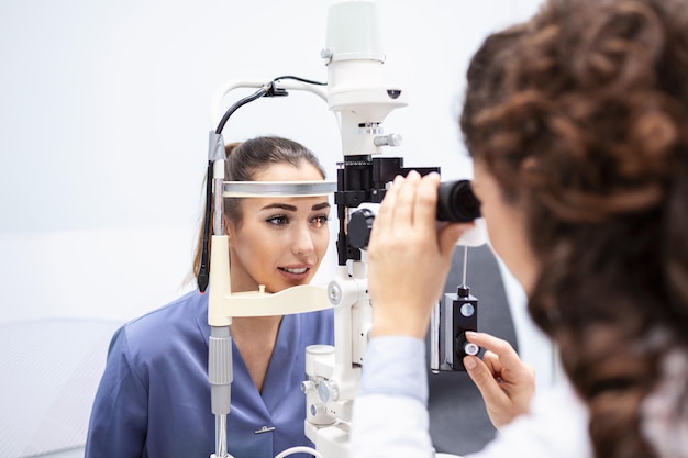 Die Augenärztin überprüft das Sehvermögen einer attraktiven jungen Frau in einer modernen Klinik Arzt und Patientin in der Augenklinik