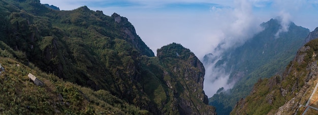 Die Aussicht von der Spitze des Fansipan-Berges im Sapa Hoang Lien Son-Gebirge Felsige Berggipfel tauchen durch die nebligen Wolken bei Lao Cai auf Malerische Luftaufnahme Fliegen Sie über Wolken oder Nebel