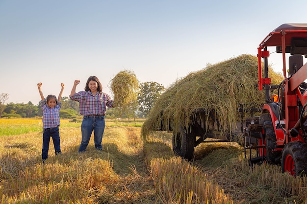 Die Bauernmutter und ihre Tochter auf Reisfeldern mit Traktor nach der Ernte