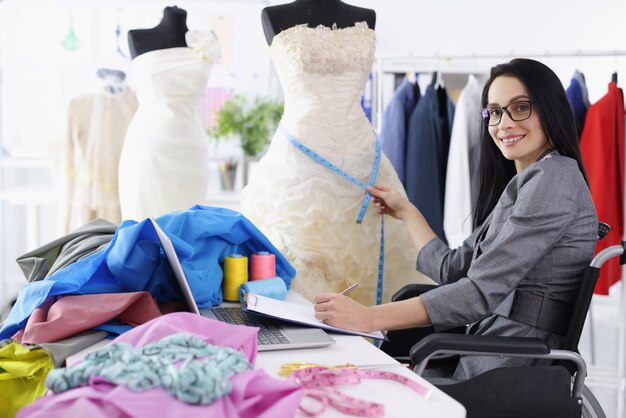 Die behinderte Designerin bietet Dienstleistungen zum Nähen von Brautkleidern an. Berufe für Menschen