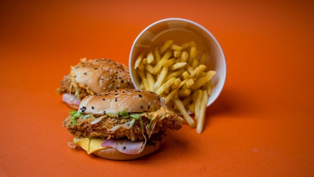 Die beiden Hamburger und Pommes auf orangefarbenem Hintergrund