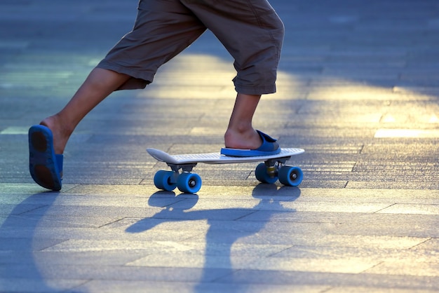 Foto die beine eines teenagers, der auf einem skateboard rollt