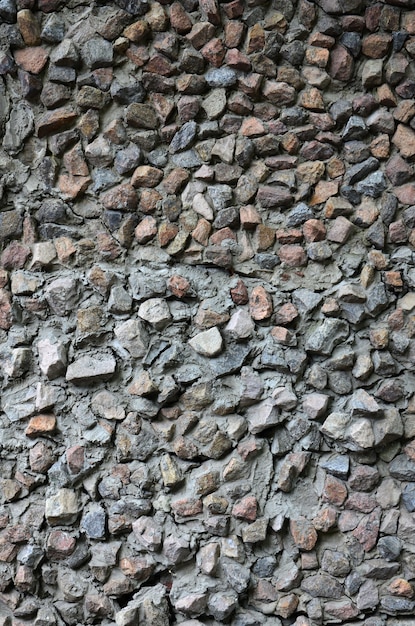 Die Beschaffenheit einer starken Steinmauer vieler betonierter Steine der verschiedenen Formen