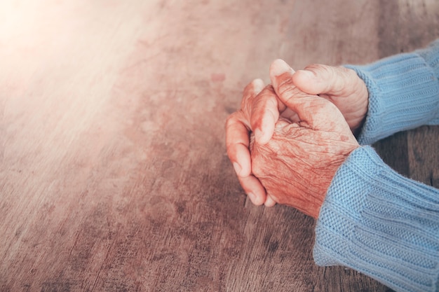 Foto die betende hand des alten. konzept: hoffnung, glaube, dramatische einsamkeit, traurigkeit, depression, weinen, enttäuscht, gesundheitswesen, schmerz.