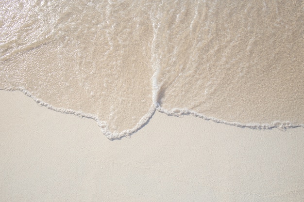 Die Bewegung der Wellen auf dem Sand ist glatt und fein für den Hintergrund