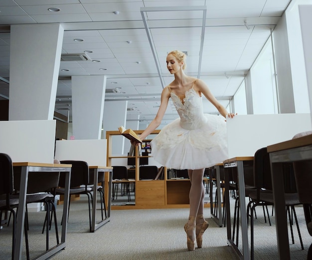 Die bezaubernde Ballerina ging in die Bibliothek, um sich während einer Pause ein neues Buch auszusuchen und zeigte Ihre Dehnung und Flexibilität