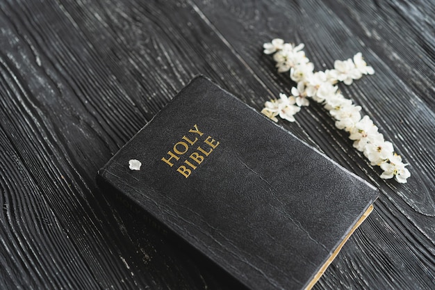 Die Bibel mit Frühlingsblumen auf einem hölzernen Hintergrund Konzept für Glauben, Spiritualität und Religion Konzept für Frieden, Hoffnung und Träume
