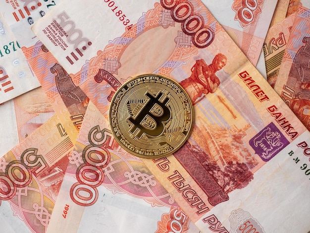 Die Bitcoin-Münze liegt auf dem Hintergrund russischer Rubel Kryptowährungsbergbau und Bergbaukonzept Draufsicht flach gelegt