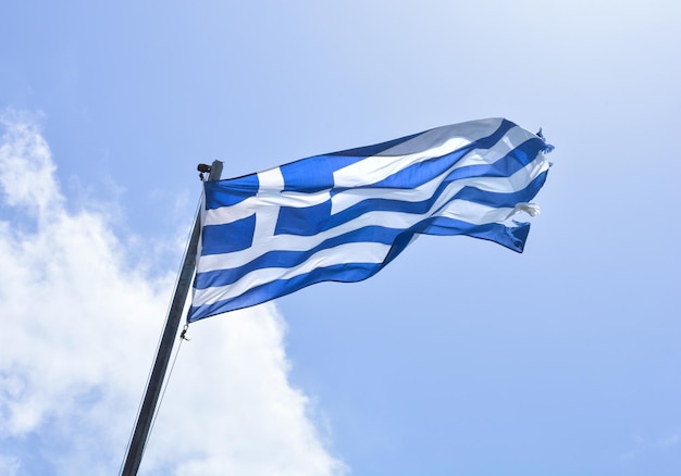 Die blau-weiße griechische Flagge weht gegen den blauen Himmel