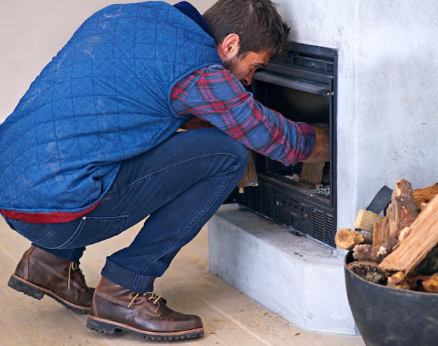 Die Blockade beseitigen Aufnahme eines jungen Mannes, der zu Hause ein Feuer in seinem Kamin macht