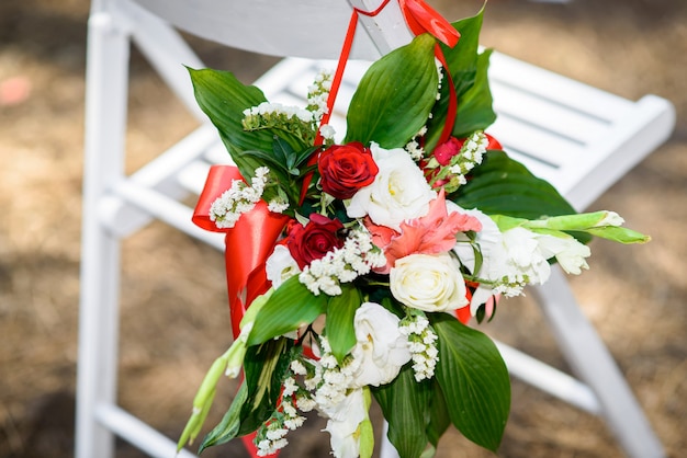Die Blumen auf dem Stuhl sind die Dekoration für die Hochzeitszeremonie.