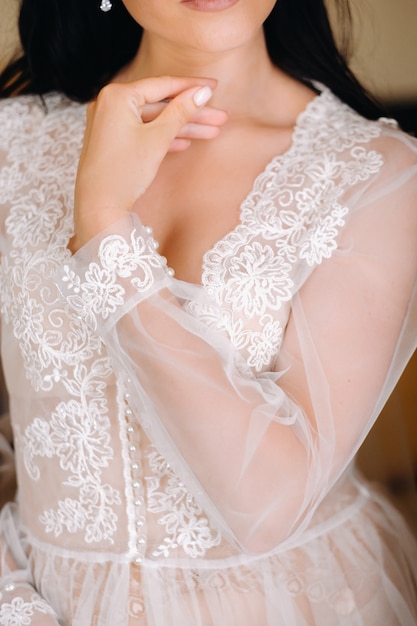 Die Braut, gekleidet in ein transparentes Boudoirkleid und Unterwäsche, steht morgens zu Hause