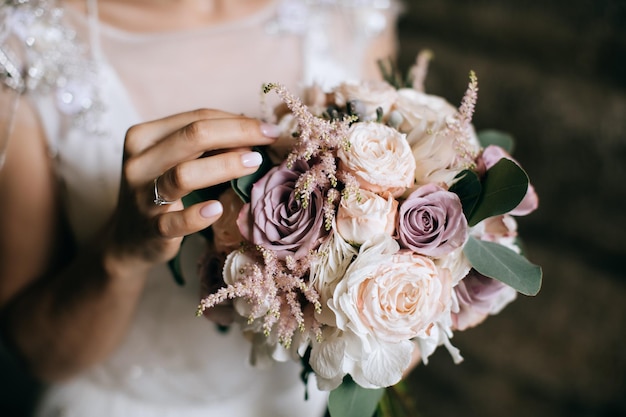 Die Braut hält einen wunderschönen Hochzeitsstrauß aus rosa und weißen Blumen in ihren Händen x9