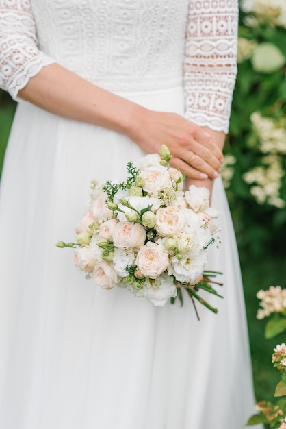 Die Braut hält ihren Hochzeitsstrauß mit weißen und rosa Blüten in Nahaufnahme