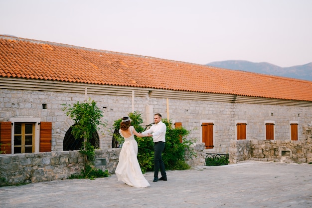 Die Braut und der Bräutigam tanzen in der Nähe der Kirche in der Altstadt von Budva