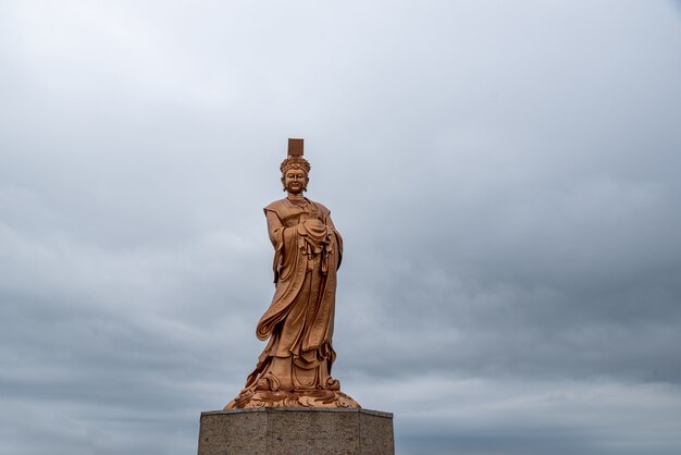 Die Bronzestatue der chinesischen religiösen Göttin bei bewölktem Wetter