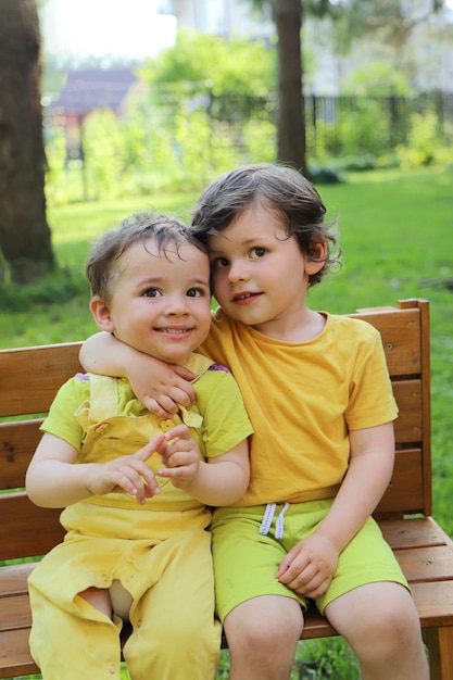 Die Brüder sitzen im Sommer im Freien zusammen auf einer Bank